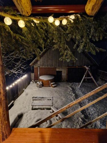 a barn with snow on the ground and lights at Chalupa nad sadom in Liptovská Kokava