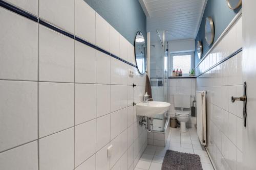 a bathroom with a sink and a toilet at 94 Relax Homedesign Ferienwohnung in Elmshorn bei Hamburg in Elmshorn