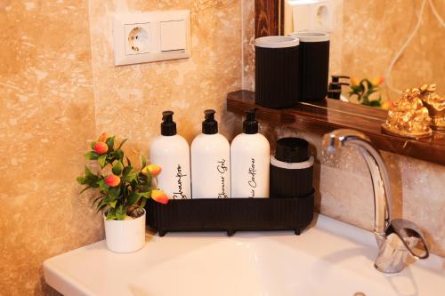 a shelf over a sink with three bottles of wine at Yellow Stone House in Goreme