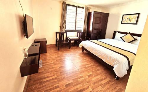 a bedroom with a bed and a television in it at Khách Sạn Thụy Điển SaPa in Sa Pa