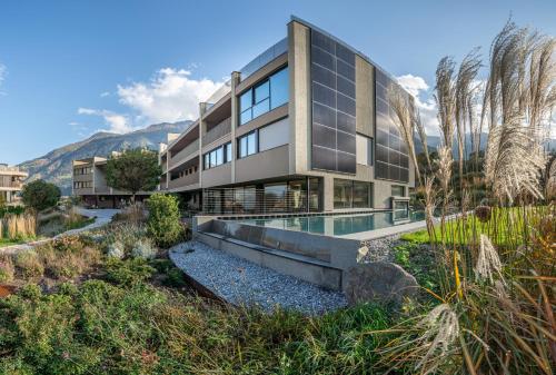 a building with a swimming pool and mountains in the background at Boutique Hotel AMARIL in Castelbello-ciardes