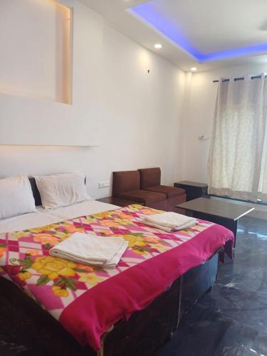 a bedroom with a large bed and a couch at Uday Sunset View Villas By Royal Collection Hotels in Nainital