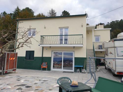 a white house with a balcony and a patio at Casa Oriana - Serra da Estrela in São Paio