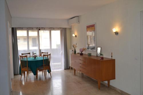 une salle à manger avec une table et des chaises vertes dans l'établissement Cannes La Baronne, à Cannes