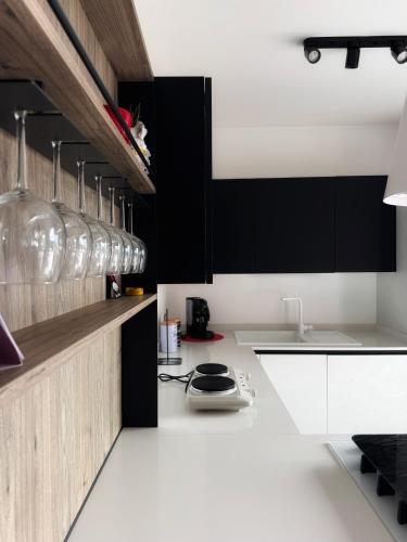 a kitchen with white counters and black cabinets at Airport Loft - Casa Giulia in CTA