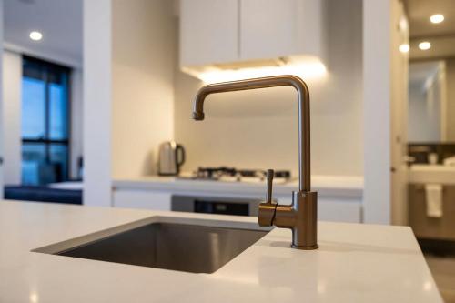 a kitchen counter with a sink in a kitchen at Modern 2BR Abode with Balcony View Gym Access in Glen Waverley