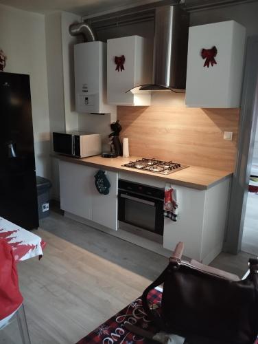 une cuisine avec des armoires blanches et un four à plaques de cuisson dans l'établissement Charmant appartement de 3 pièces, Colmar, à Colmar