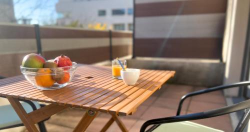 - un bol de fruits sur une table en bois sur un balcon dans l'établissement AC - Central Station - Appart' Hotel, à Avignon