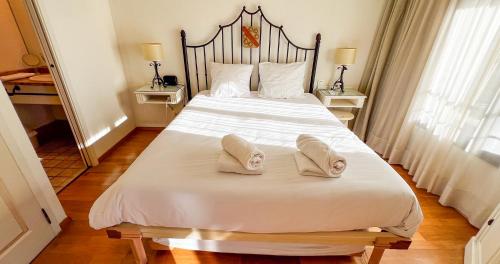 - une chambre avec un grand lit blanc et des chaussons dans l'établissement AC - Central Station - Appart' Hotel, à Avignon