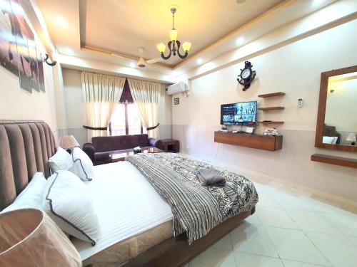 a bedroom with a large bed and a television at The Signature Studio's in Rawalpindi