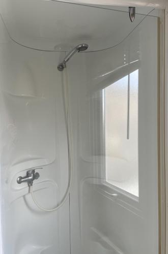 une douche dans une salle de bain avec une porte vitrée dans l'établissement Mobile home 40m2 - 2 bathroom - Cc725 Les Charmettes 4 stars, aux Mathes