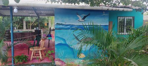 a mural on the side of a house with a chair at cabañita natural verde in La Ceiba
