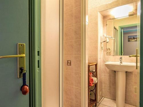 een badkamer met een wastafel en een spiegel bij La Maison de Saint-Hernot in Crozon