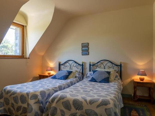 een slaapkamer met 2 bedden met blauwe en witte lakens bij La Maison de Saint-Hernot in Crozon
