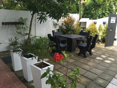 a patio with a table and chairs and plants at Little Villa Guest House in Ahangama