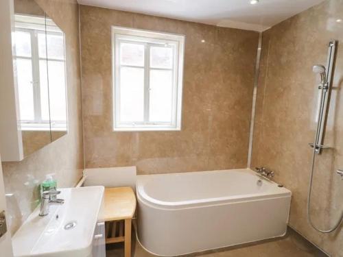 a bathroom with a white tub and a sink at Pannett Park Rooms in Whitby