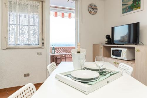 a dining room with a white table and a tv at C22 Beachfront Villa - SPA BATH, POOL, PRIVATE BEACH, PARKING FREE in Marina dʼAndora