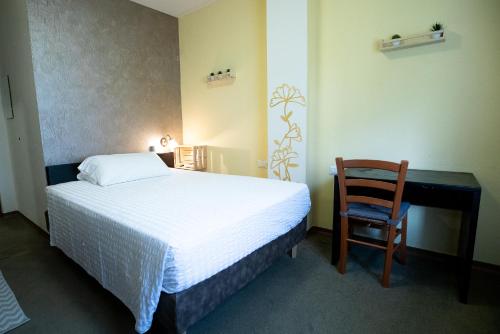 a bedroom with a bed and a desk and a chair at Hotel Rendez Vous in Châtillon