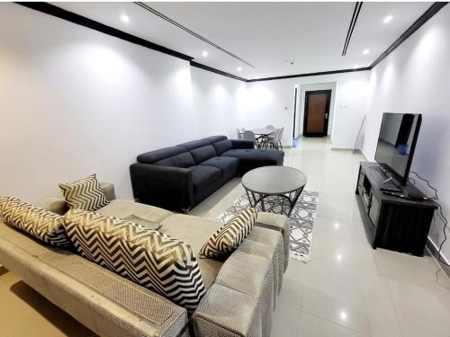 a living room with a couch and a flat screen tv at Ultimate Beachfront Experience in Ajman 
