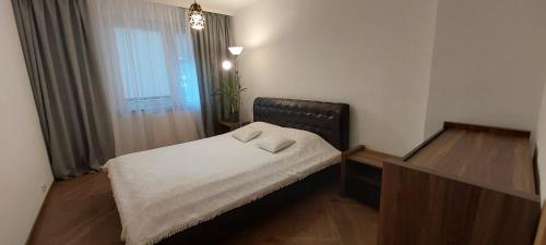 a small bedroom with a bed and a window at Apartament przy Stawie in Wrocław