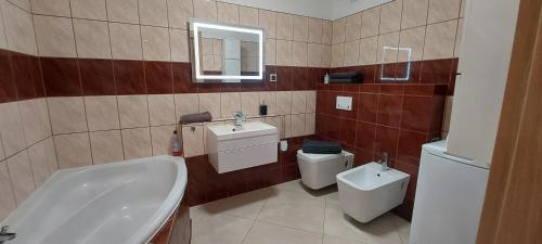 a bathroom with a sink and a toilet and a tub at Apartament przy Stawie in Wrocław