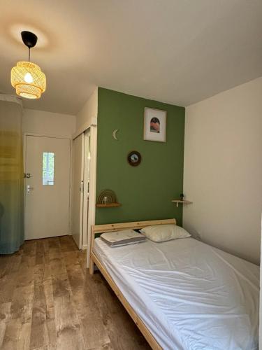 - une chambre dotée d'un lit avec un mur vert dans l'établissement Studio Nid sur la Cascade, à Eaux-Bonnes