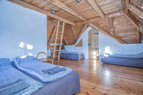 a attic room with two beds and a ladder at Nadgora SkyHouse in Žabljak