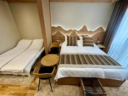 a bedroom with two beds and a large window at Apartment A27 - Aparthotel Vučko in Jahorina