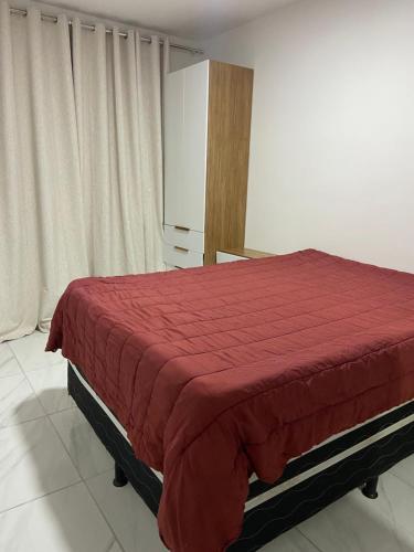 a bedroom with a bed with a red blanket at Vog caruaru in Caruaru