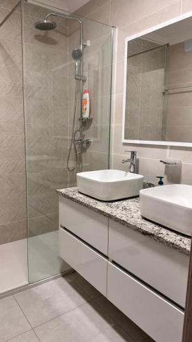 a bathroom with a sink and a glass shower at Duarte Apartments - Império in Mindelo