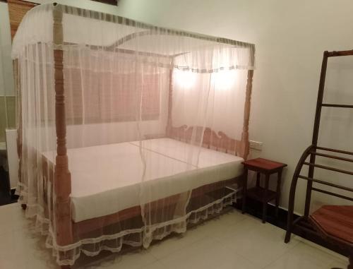 a bedroom with a canopy bed with a window at SkyWalker Guest House in Weligama