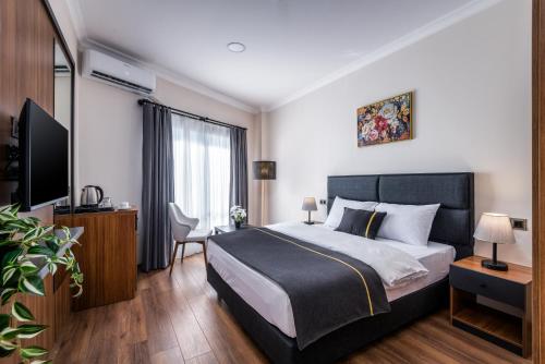 a bedroom with a bed and a flat screen tv at sh hotel business in Karşıyaka