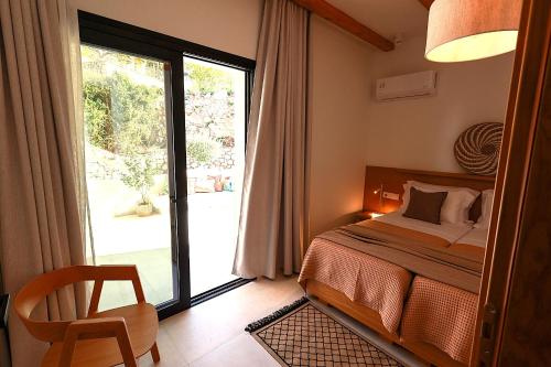 a bedroom with a bed and a sliding glass door at Aella Exclusive Residences Lefkada in Mikros Gialos