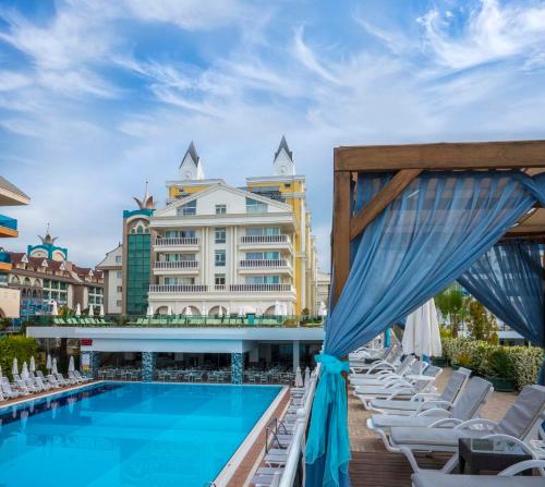 a swimming pool with chairs and a hotel at Dream World Resort & Spa in Side