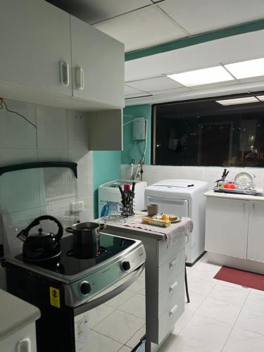 a kitchen with a stove with pots and pans on it at Parke inglés in Quito