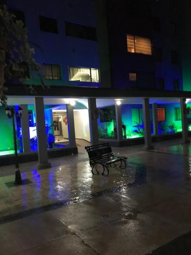 a bench in front of a building at night at Parke inglés in Quito