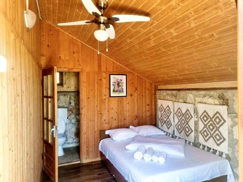 a bedroom with a bed with a ceiling fan at Marina Park in Vama Veche