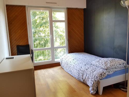 une chambre avec un lit et une fenêtre dans l'établissement 14 allée du Gacet, à Rennes