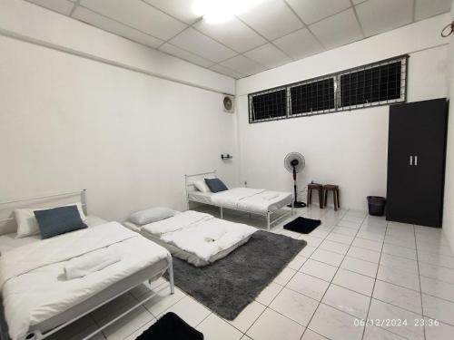 Habitación blanca con 2 camas y ventilador. en TDT STAY-Homestay, en Keningau