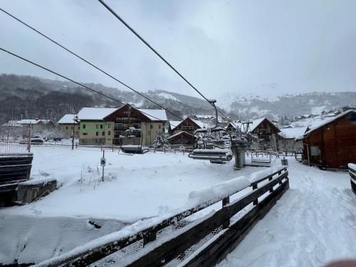 un village enneigé avec des maisons et une remontée mécanique dans l'établissement Chalet du Galibier Valloire, à Valloire