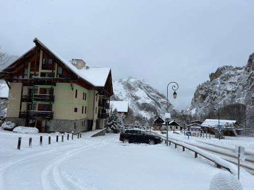 une maison avec une voiture garée dans la neige dans l'établissement Chalet du Galibier Valloire, à Valloire
