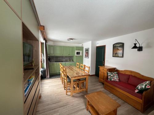 un salon avec un canapé rouge et une table dans l'établissement Chalet du Galibier Valloire, à Valloire