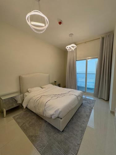 a bedroom with a bed and a large window at Luxury Two Bedroom Spacious Appartment Brand New in Ajman