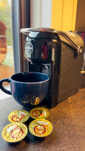 a cup of coffee next to a toaster oven at Puhkemaja metsa sees in Urvaste