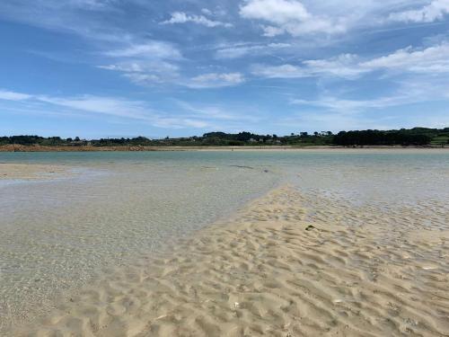 a sandy beach with footprints in the water at Amour Amour Love Room in Penvénan