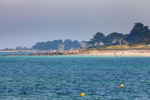 a large body of water with a beach in the background at Amour Amour Love Room in Penvénan