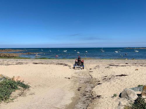 a person sitting in a wheelchair on the beach at Amour Amour Love Room in Penvénan