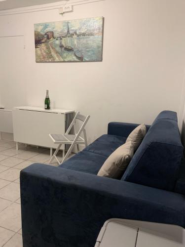 un salon avec un canapé bleu et une table dans l'établissement Cozy little duplex near Montmartre, à Paris