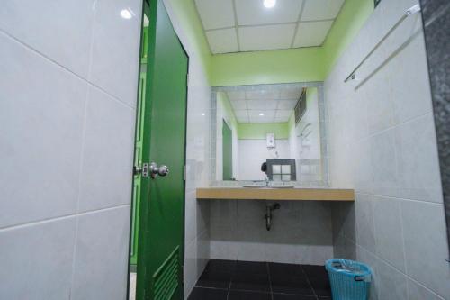 a bathroom with a sink and a mirror at โรงแรมวรัญญูเฮ้าส์ & รีสอร์ท in Maha Sarakham