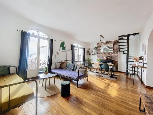 un salon avec un canapé et une table dans l'établissement Le Rodet - Proche RER E, 20 min de Paris, à Villemomble